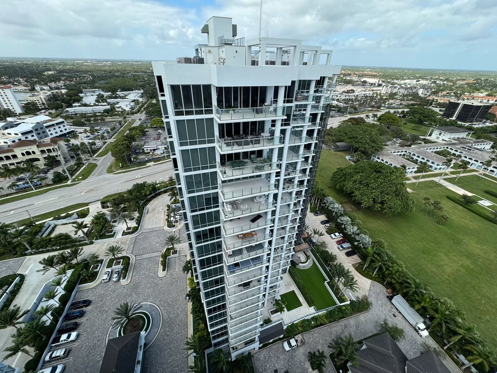 Drone view of a slender high-rise condominium tower and its motor court
