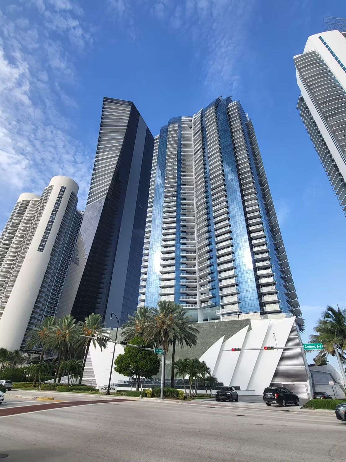Cluster of glass oceanfront condominium towers against a blue sky