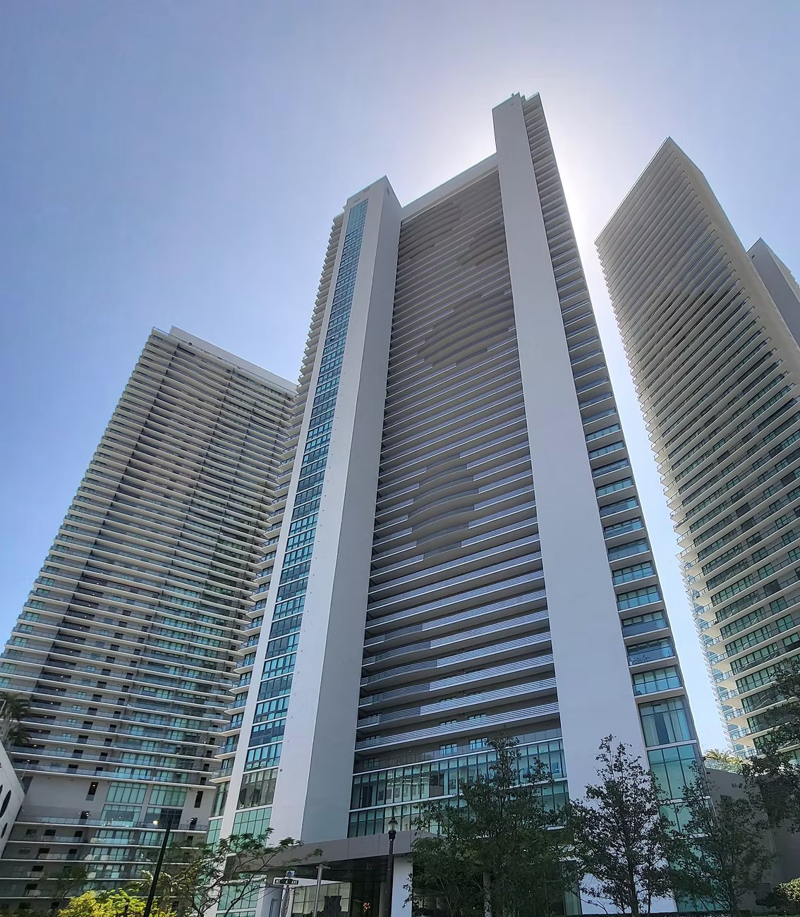 Street-level view looking up at three Miami high-rise condominium towers